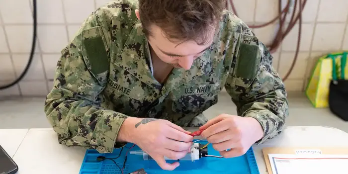 Man wearing camouflage working on robot